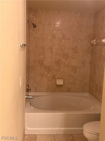 a bathroom with a granite countertop bathtub