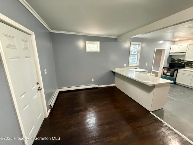 a large white kitchen with sink a refrigerator and a stove