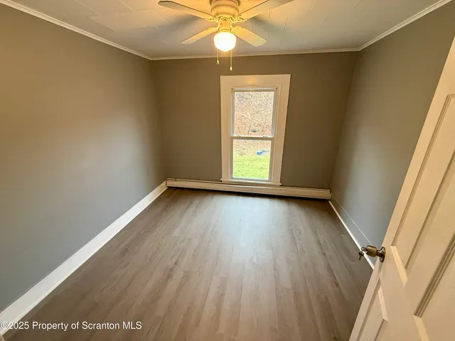 an empty room with a window and ceiling fan