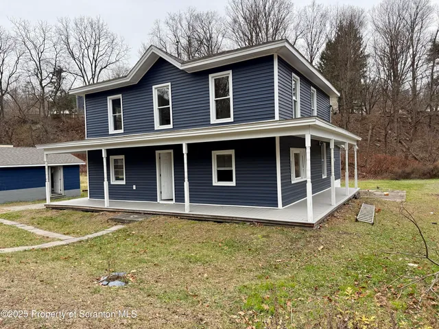 a view of a house with yard and sitting area