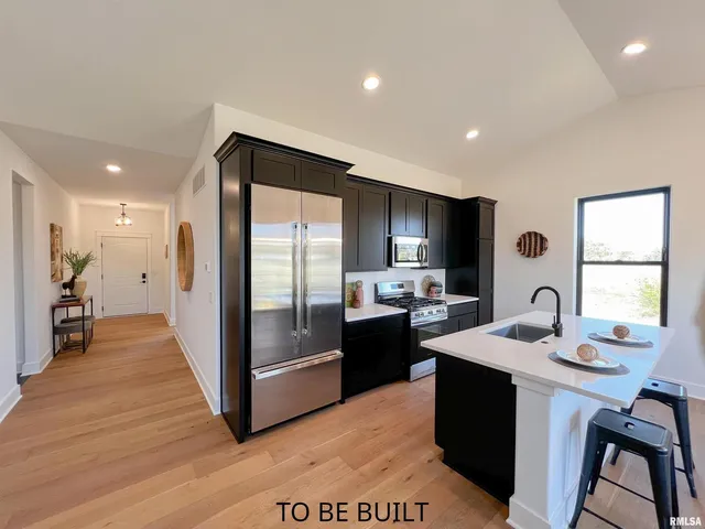 a kitchen with granite countertop a sink stove and refrigerator