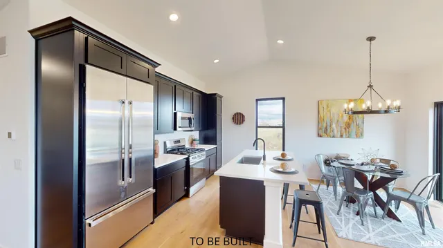 a kitchen with stainless steel appliances kitchen island granite countertop a refrigerator a stove a kitchen island a dining table and chairs with wooden floor