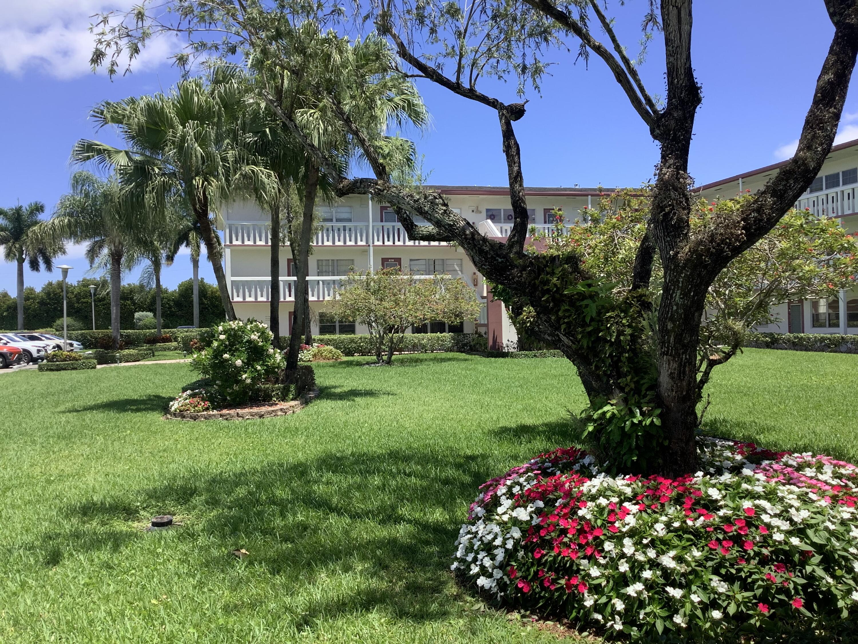 560 Fanshaw North, Unit 560 Boca Raton, FL 33434 - Photo 25 of 26 a view of a house with a big yard and potted plants