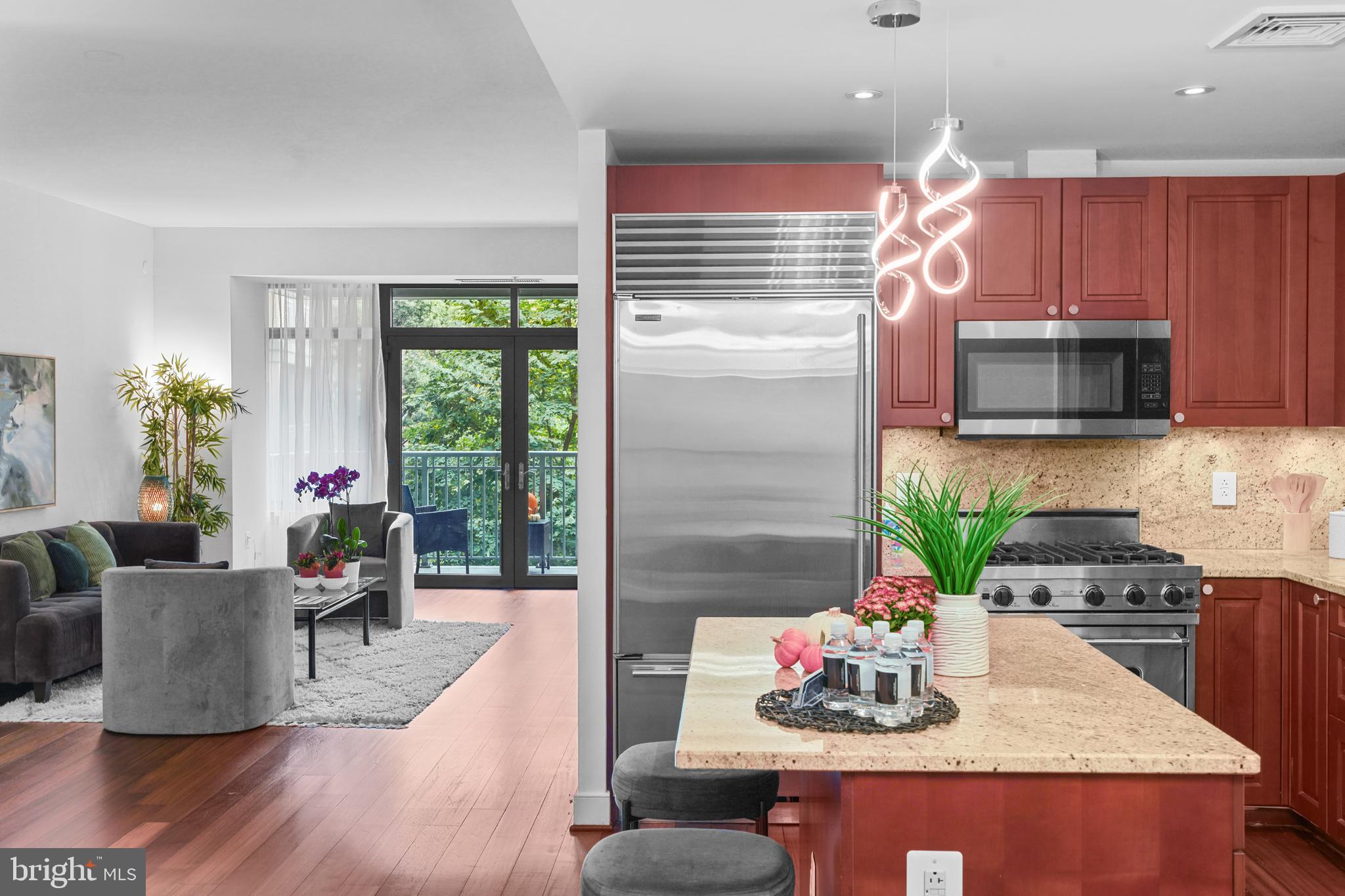 2425 L Street Northwest, Unit 431 Washington, DC 20037 - Photo 14 of 29 a kitchen with stainless steel appliances granite countertop a stove top oven a dining table and chairs with wooden floor