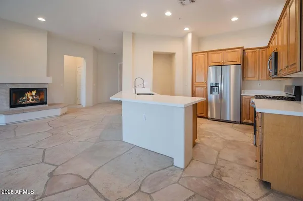 a kitchen with stainless steel appliances granite countertop a refrigerator and a stove top oven