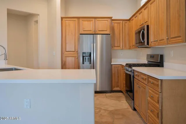 a kitchen with granite countertop a refrigerator stove and microwave