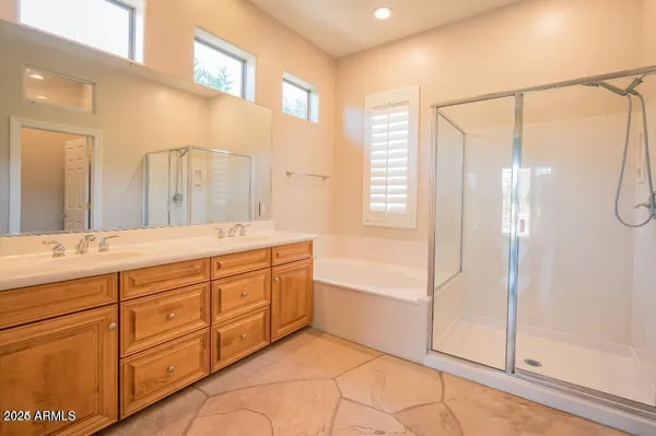 a spacious bathroom with a tub sink shower and mirror