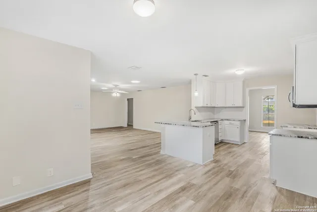 a large kitchen with kitchen island a sink stainless steel appliances and white cabinets