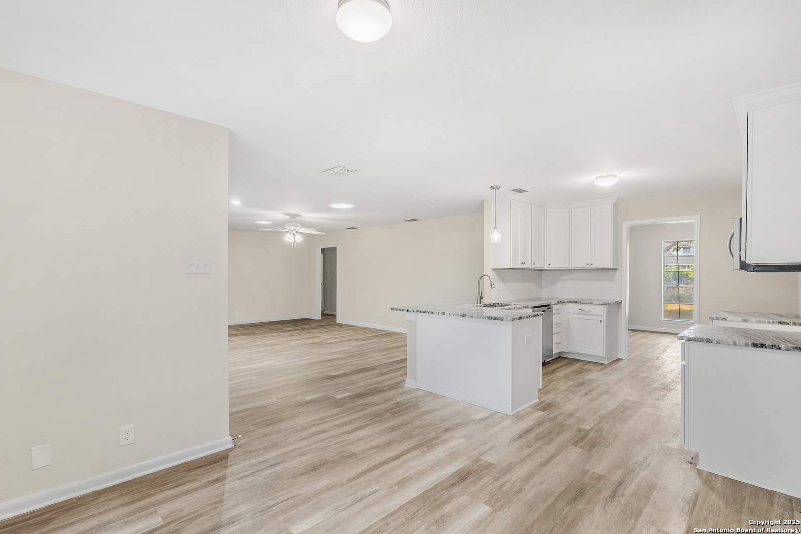 6041 Trone Trail Leon Valley, TX 78238 - Photo 12 of 30 a large kitchen with kitchen island a sink stainless steel appliances and white cabinets