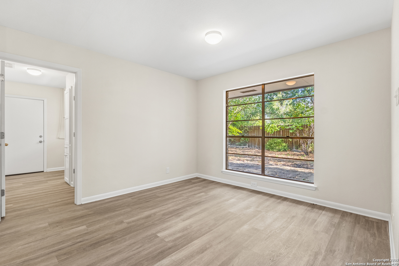 6041 Trone Trail Leon Valley, TX 78238 - Photo 20 of 30 a view of an empty room with wooden floor and a window