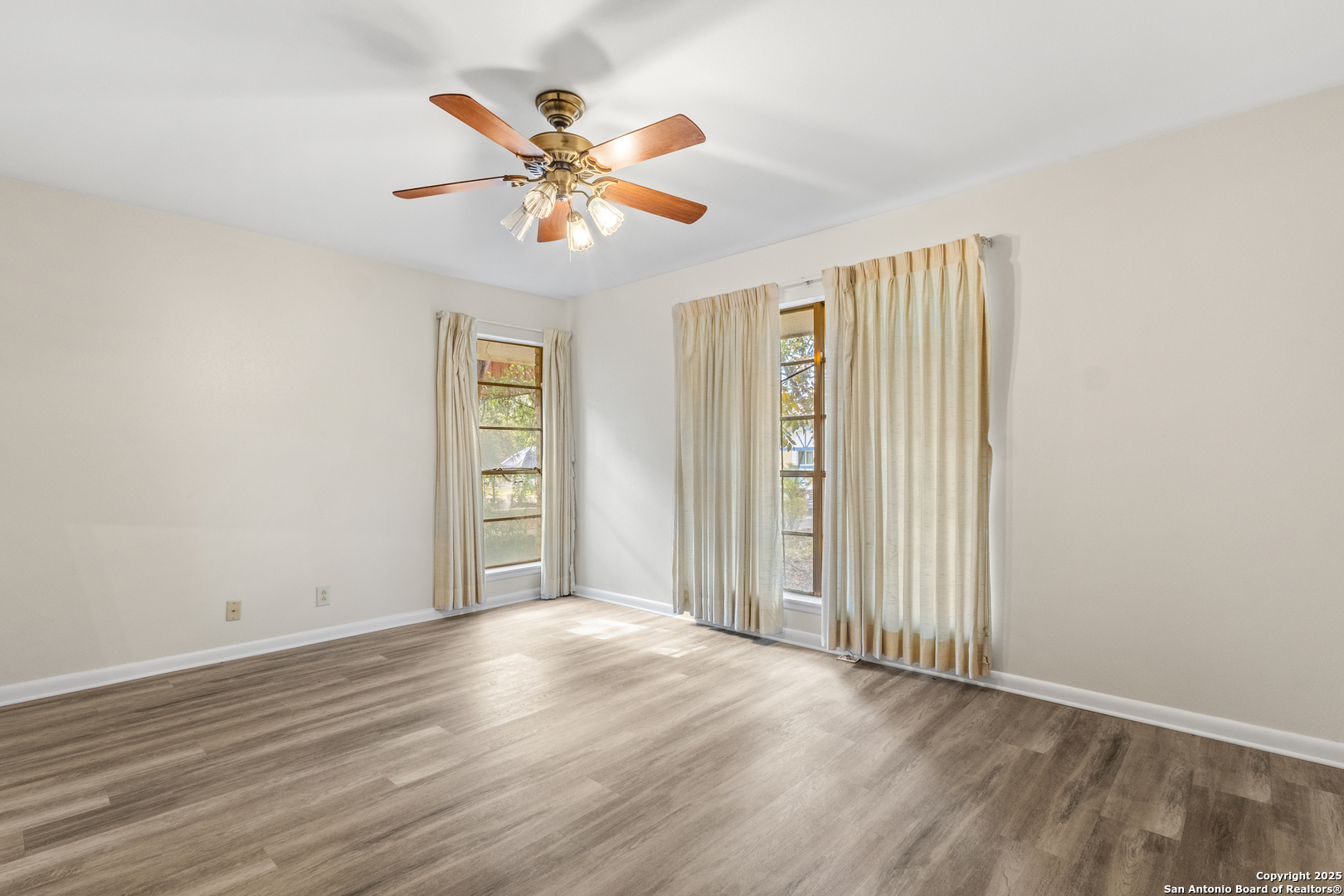 6041 Trone Trail Leon Valley, TX 78238 - Photo 21 of 30 a view of an empty room with wooden floor and a window