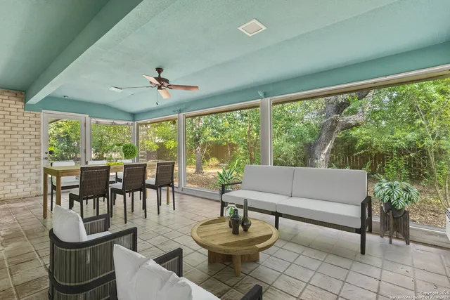 a living room with fireplace furniture and a large window