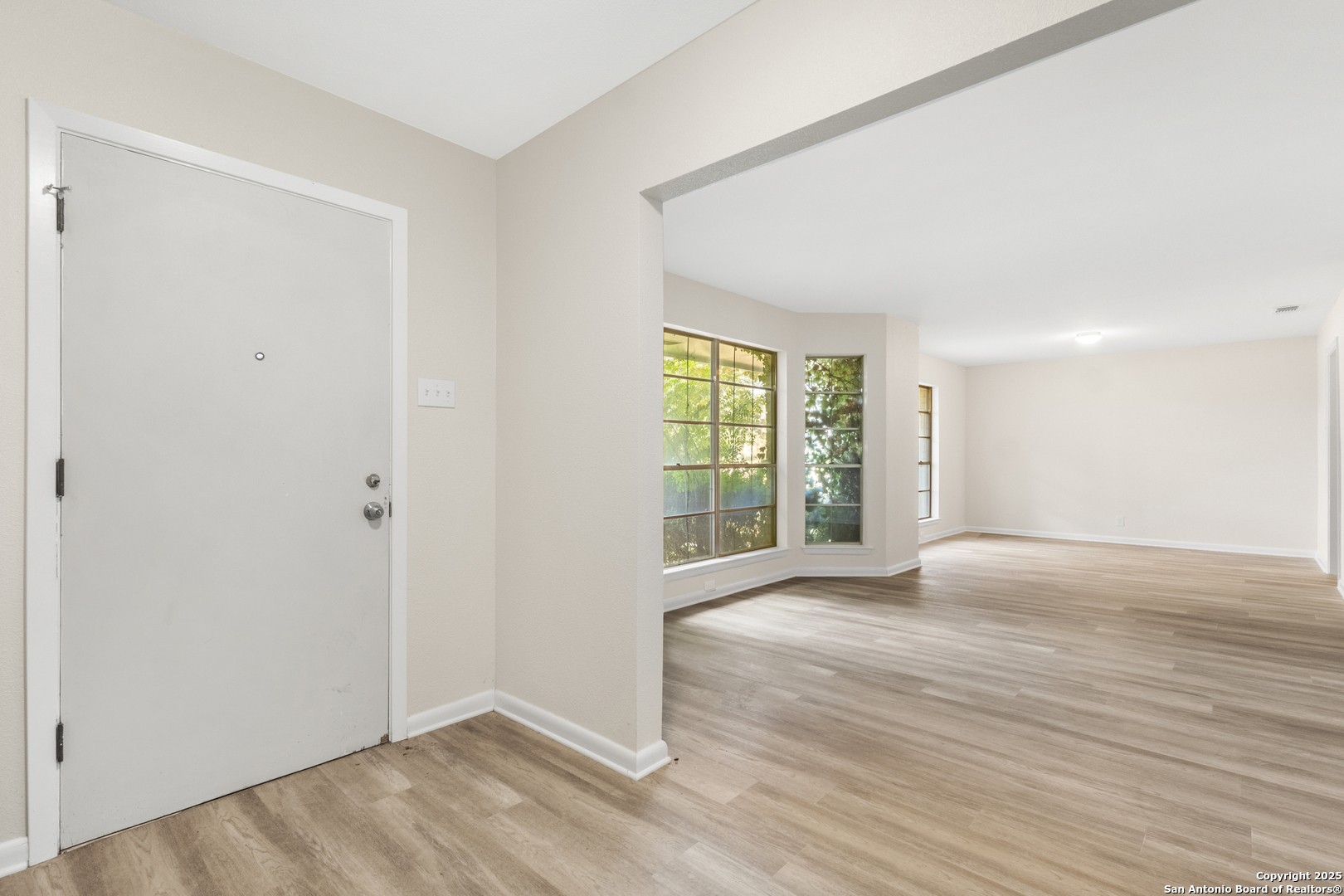 6041 Trone Trail Leon Valley, TX 78238 - Photo 3 of 30 a view of an empty room with wooden floor and a window