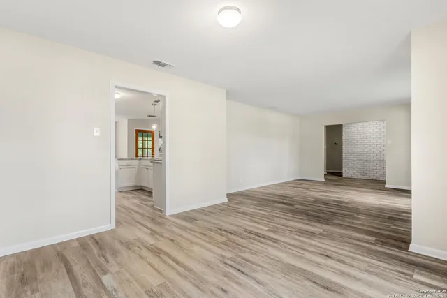 a view of empty room with wooden floor