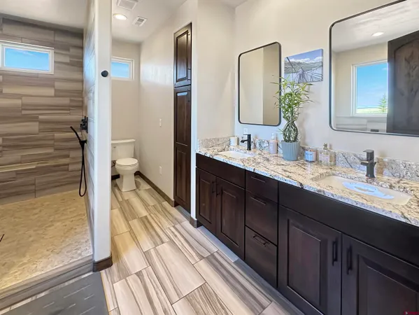 a spacious bathroom with a double vanity sink a mirror and a