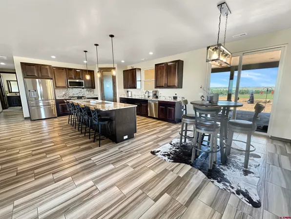 a living room with furniture a flat screen tv and kitchen view