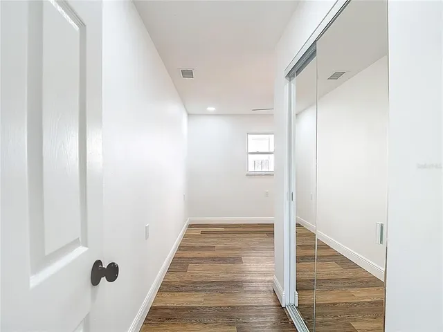 a view of a hallway with wooden floor and staircase