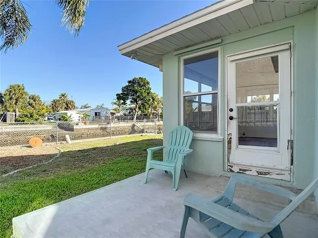 a view of a chair and table in backyard of the house