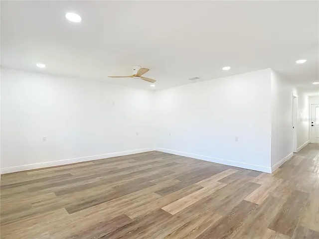 a view of a room with wooden floor and white walls