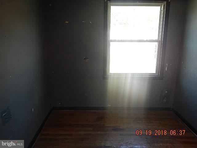 1635 Riverwood Road Baltimore, MD 21221 - Photo 17 of 30 a view of an empty room with wooden floor and a window