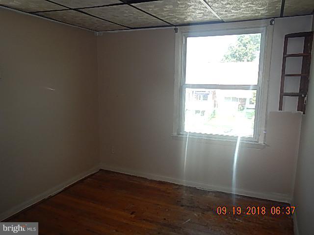 1635 Riverwood Road Baltimore, MD 21221 - Photo 20 of 30 a view of an empty room with wooden floor and a window