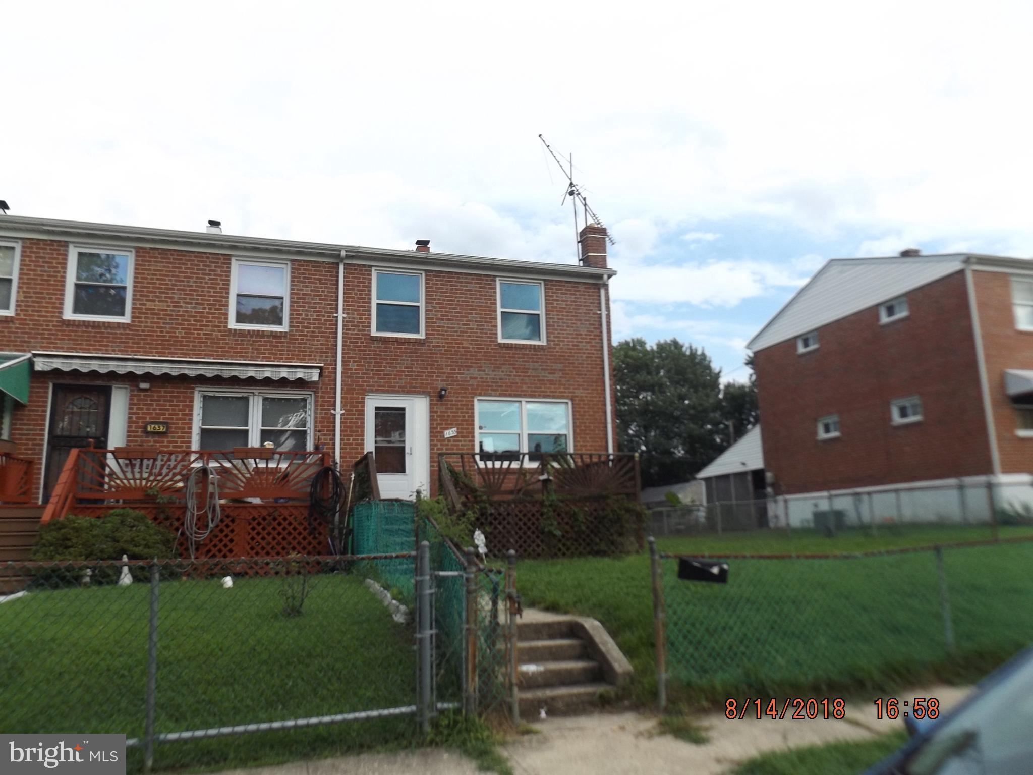 1635 Riverwood Road Baltimore, MD 21221 - Photo 9 of 30 a view of a brick house next to a yard with big trees