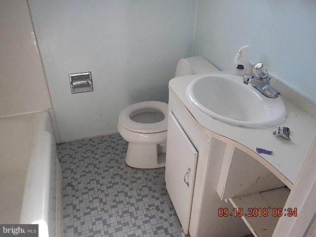 1635 Riverwood Road Baltimore, MD 21221 - Photo 10 of 30 a white toilet sitting next to a bathroom sink