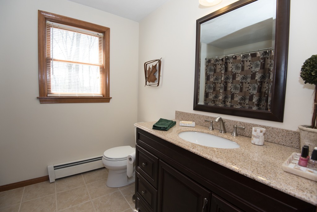 35 Acorn Road Northbridge, MA 01588 - Photo 18 of 23 a bathroom with a granite countertop sink a large mirror a toilet and a window