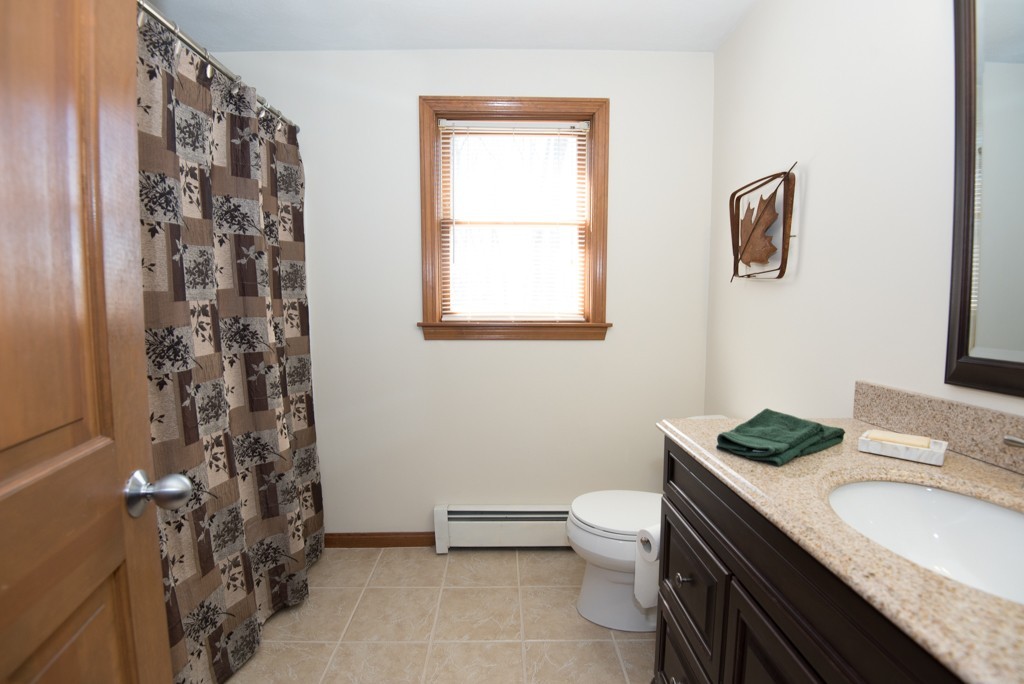 35 Acorn Road Northbridge, MA 01588 - Photo 19 of 23 a bathroom with a granite countertop toilet a sink a mirror a window and a shower