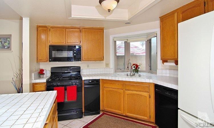 2921 Fanshell Walk Oxnard, CA 93035 - Photo 6 of 20 a kitchen with a sink a stove and a microwave