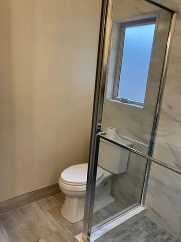 a bathroom with a toilet and a shower