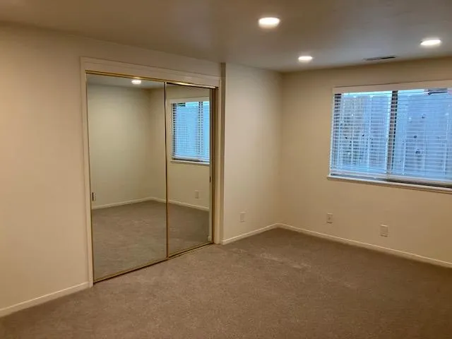 an empty room with windows and closet