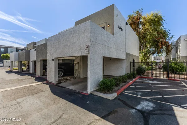 a front view of a house with yard and parking