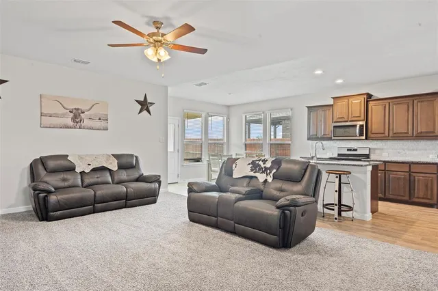 a living room with furniture kitchen view and a window