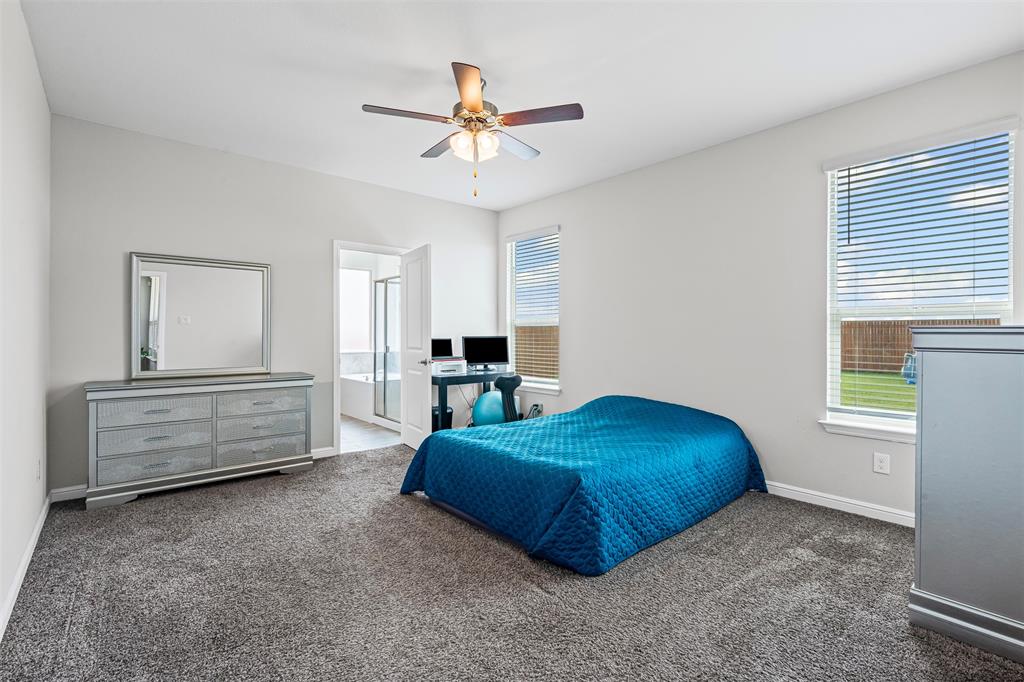 1104 Dublin Drive Cleburne, TX 76033 - Photo 20 of 39 Bedroom featuring dark colored carpet, multiple windows, ceiling fan, and ensuite bathroom