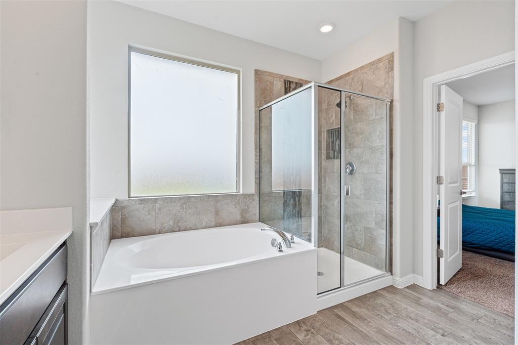 1104 Dublin Drive Cleburne, TX 76033 - Photo 24 of 39 Ensuite bathroom with light wood-style flooring, a stall shower, a garden tub, and vanity