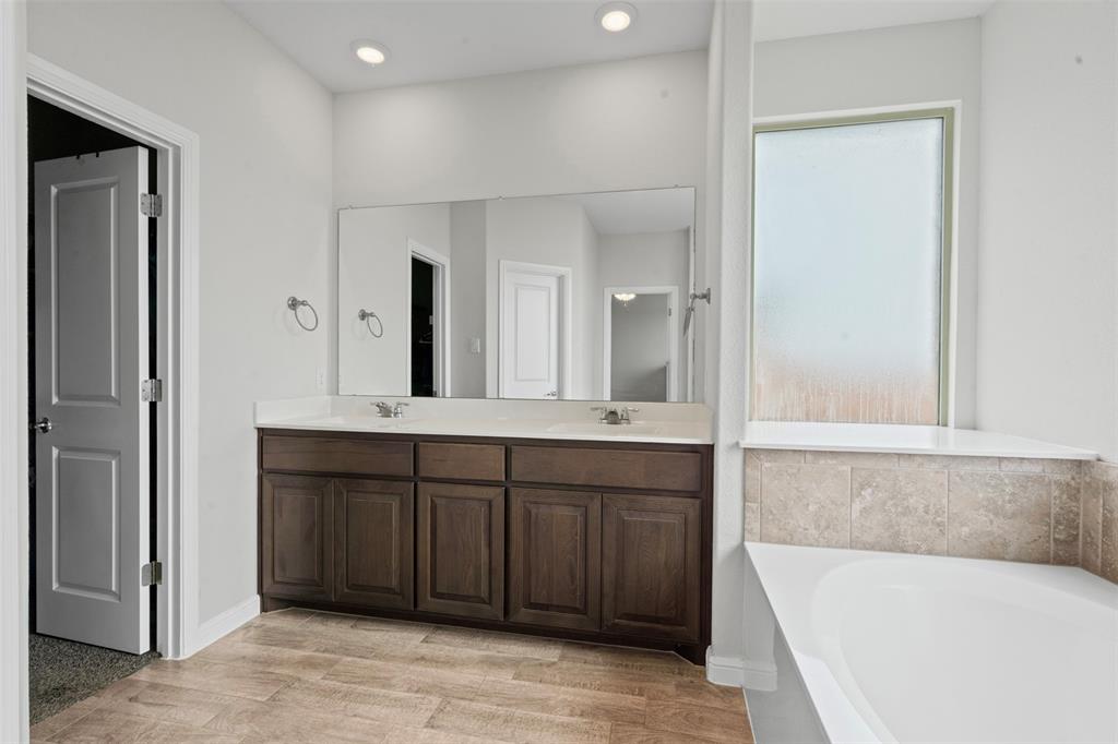 1104 Dublin Drive Cleburne, TX 76033 - Photo 25 of 39 Full bathroom with double vanity, a garden tub, light wood finished floors, and recessed lighting
