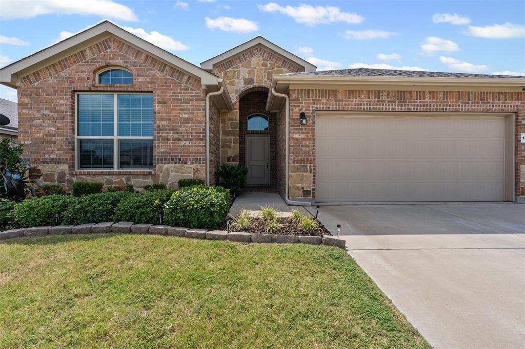 1104 Dublin Drive Cleburne, TX 76033 - Photo 6 of 39 View of front of home featuring stone siding, concrete driveway, brick siding, a front lawn, and a garage