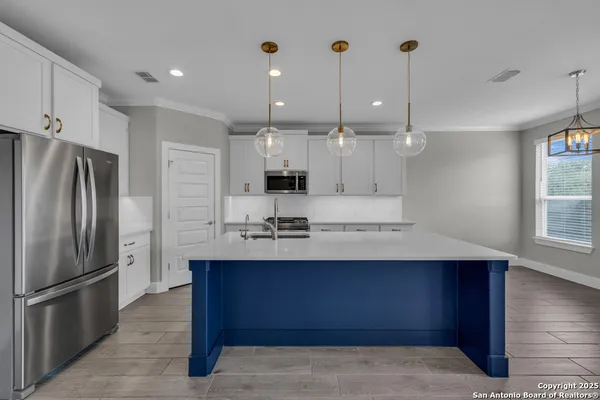 a large kitchen with kitchen island a sink stainless steel appliances and cabinets