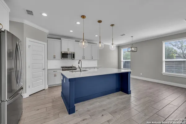 a kitchen with white cabinets stainless steel appliances and sink