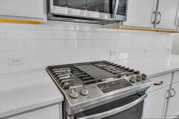 a kitchen with stainless steel appliances a stove refrigerator sink and microwave
