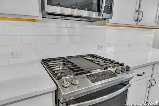 a kitchen with stainless steel appliances a stove refrigerator sink and microwave