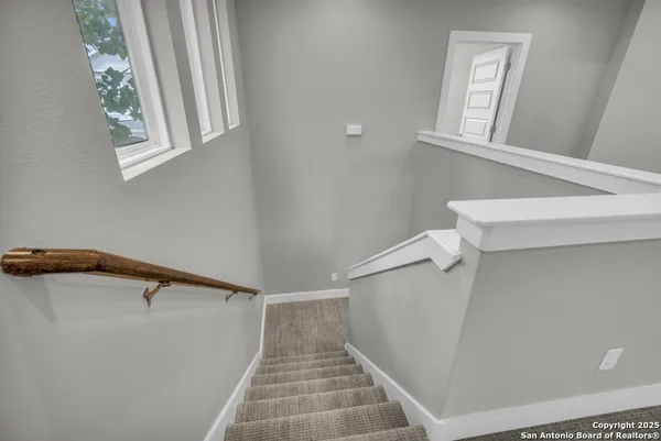 an empty room with wooden floor and a ceiling fan