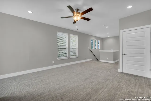 an empty room with closet and ceiling fan