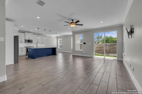 a view of an empty room with glass door and windows