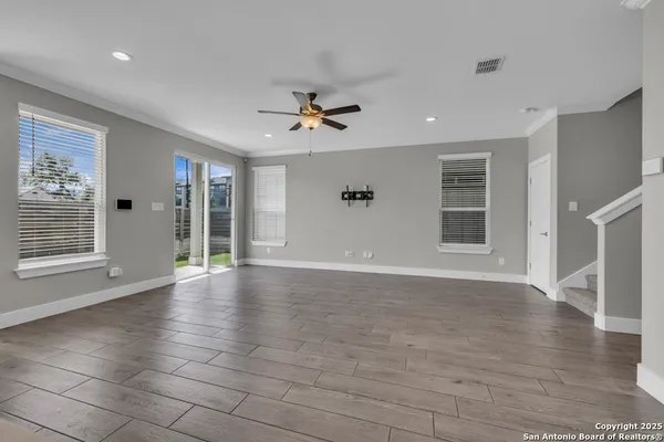 an empty space with wooden floor and a ceiling fan