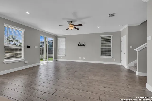 an empty space with wooden floor and a ceiling fan