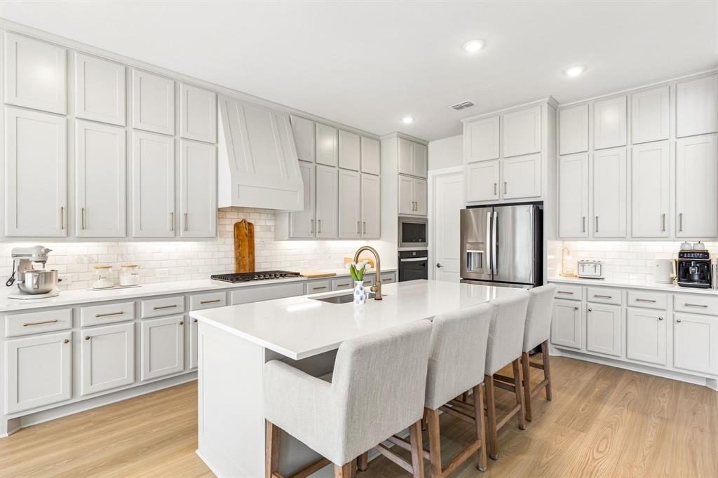 3004 Windy Rdg Road McKinney, TX 75071 - Photo 3 of 40 a kitchen with a white cabinets and chairs
