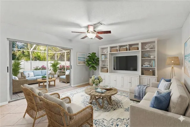 a living room with furniture a flat screen tv and a large window