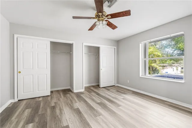 a view of a room with wooden floor and ceiling fan